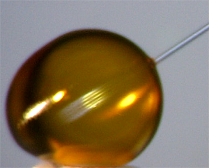 Cleaning a plastic capsule with a solvent stream.